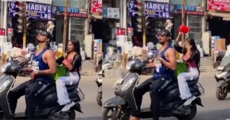 Viral Video: बीच सड़क पर चलती स्कूटी पर नहाने लगा कपल, वीडियो वायरल होते ही दर्ज हुई शिकायत